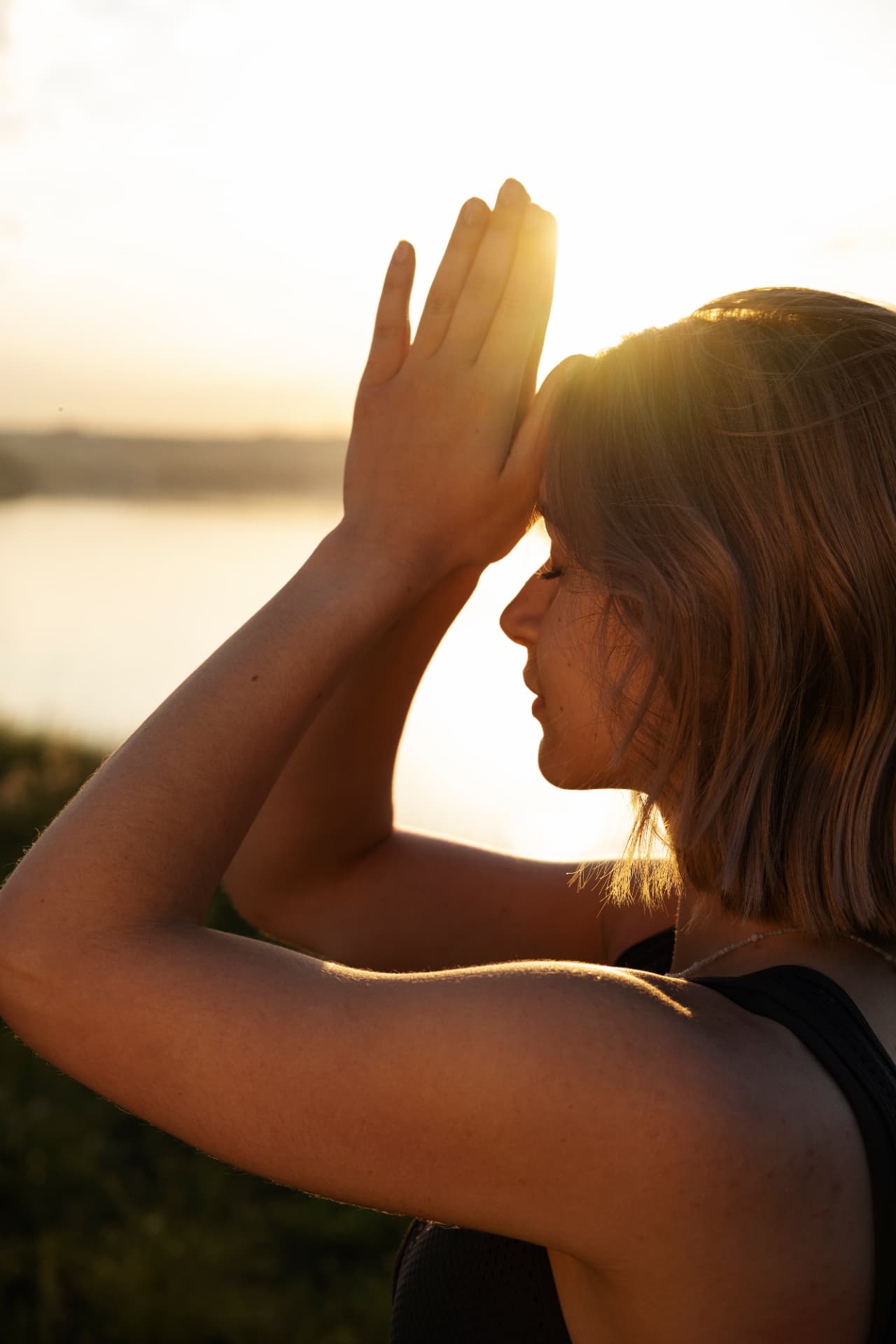 Femeie meditând în lumina caldă a apusului